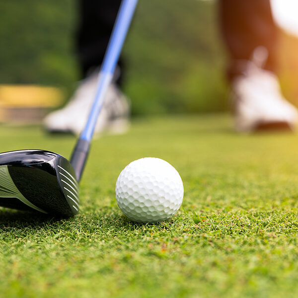 Golf ball on green grass ready to be struck at golf club,close up in golf coures at Thailand